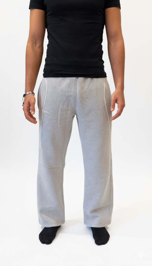 Person wearing gray wide-leg pants and a black top on a white background from Noor Apprel.